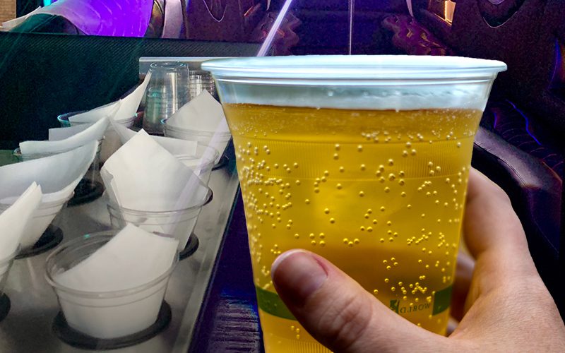 A person holding a plastic cup fill of beer on the Bemidji Party Bus.